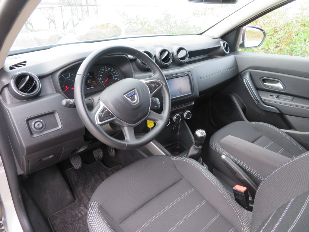 Intérieur Dacia Duster Prestige avec accoudoir central et écran tactile.