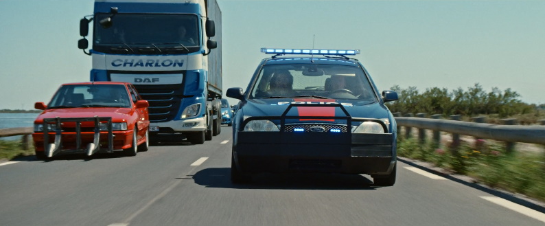 R21 rouge utilisée dans le film Balle perdue en pleine course-poursuite avec une Ford Mondéo bleu de la police.