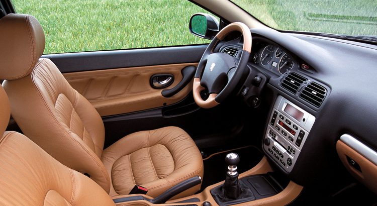 Peugeot 406 coupé, vue de l'intérieur avec plastique noir et cuir marron.