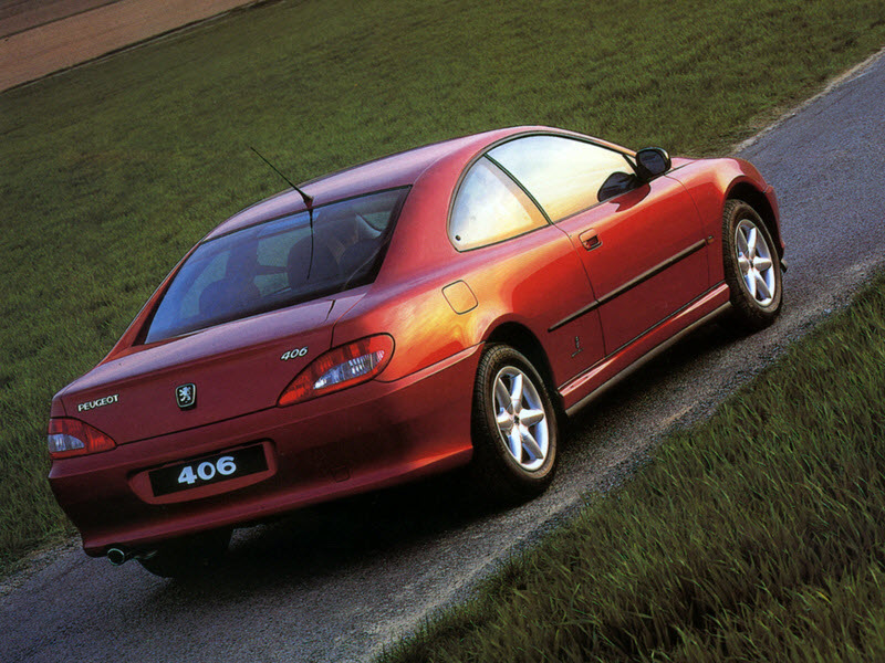 Peugeot 406 coupé rouge vue d 3/4 arrière sur route.