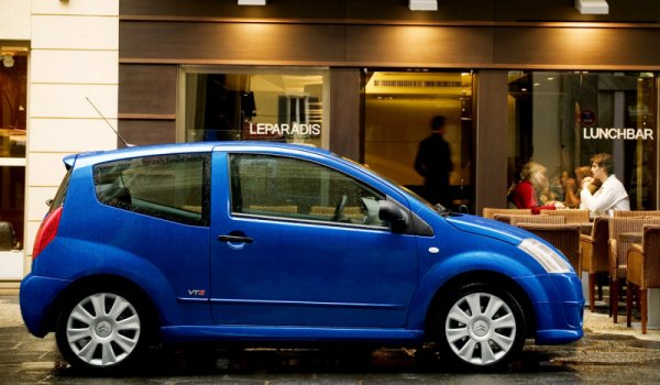 Citroën C2 VTS bleue vue de profil devant un bar parisien.