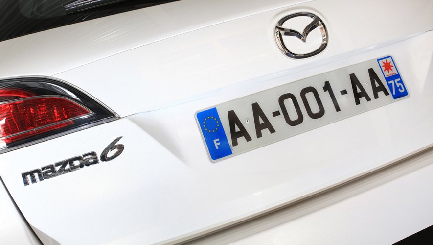 Première plaque du système SIV AA-001-AA posée sur coffre Mazda 6 break blanc.