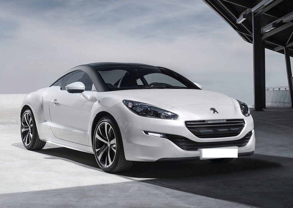 Peugeot RCZ diesel de couleur blanche avec toit noir garée sous un bâtiment.