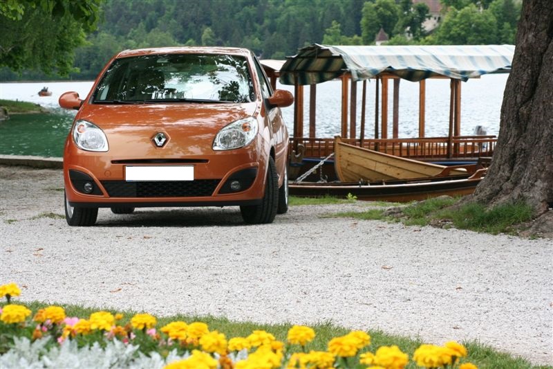 Renault Twingo 2 de couleur orange devant quai et bateau.