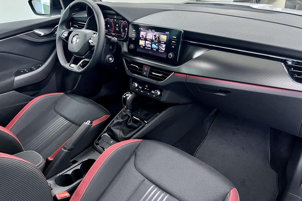 Intérieur Skoda Kamiq restylé avec imitation carbone et liserés rouges.