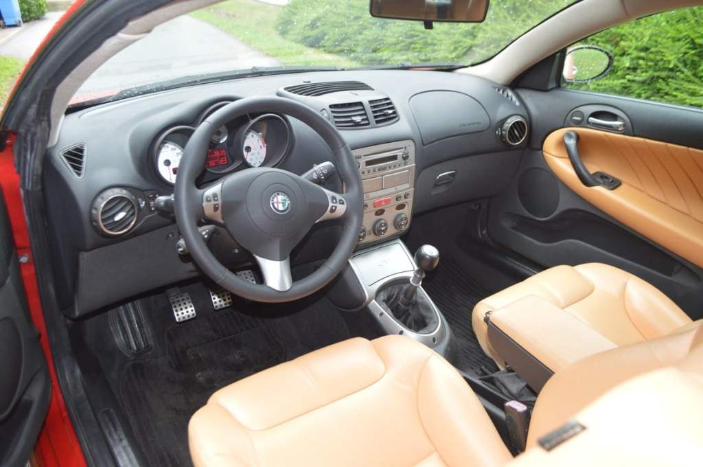 Intérieur Alfa Roméo GT 3.2 V6 Busso avec cuir marron et cadrans blancs sur tableau de bord.