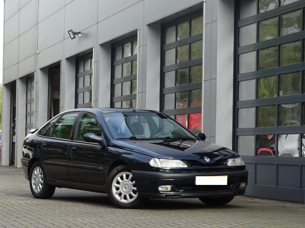 Renault Laguna V6 PRV finition Baccara noire devant portes de garage.